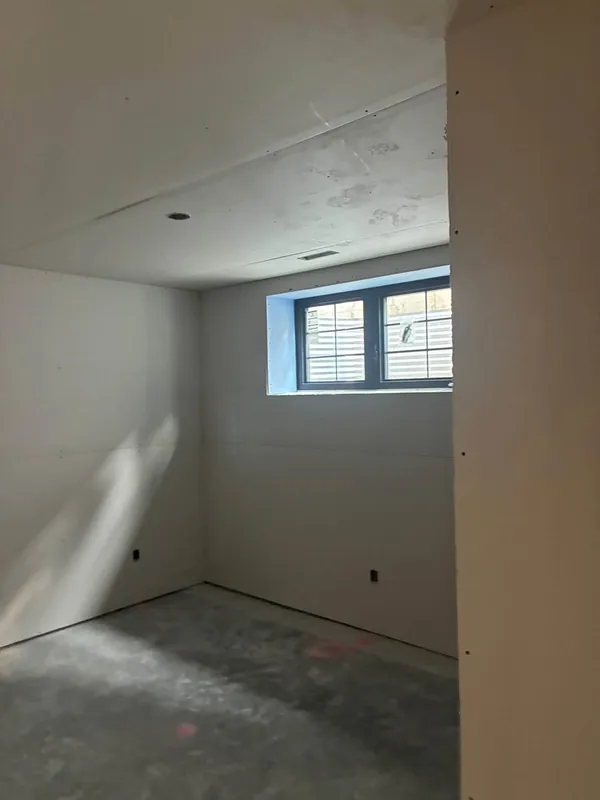 Ceiling seams coated with joint compound and partly taped in an interior under construction